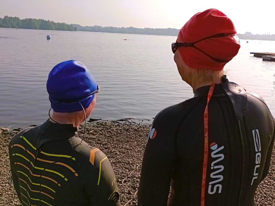 two swimmers wearing swim caps